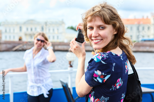 Female photographer turning back with hand-held camera photo