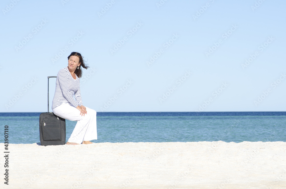 Single woman waiting with case at seaside Single woman waiting with case at seaside