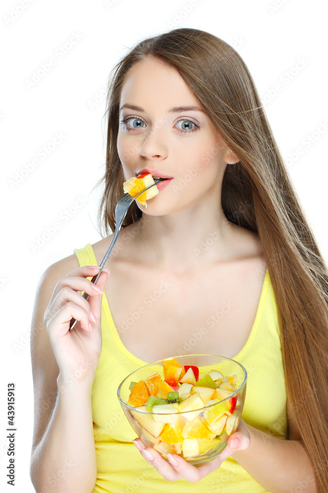 Portrait of a young woman eating fruit salad isolated on a white Portrait of a young woman eating fruit salad isolated on a white