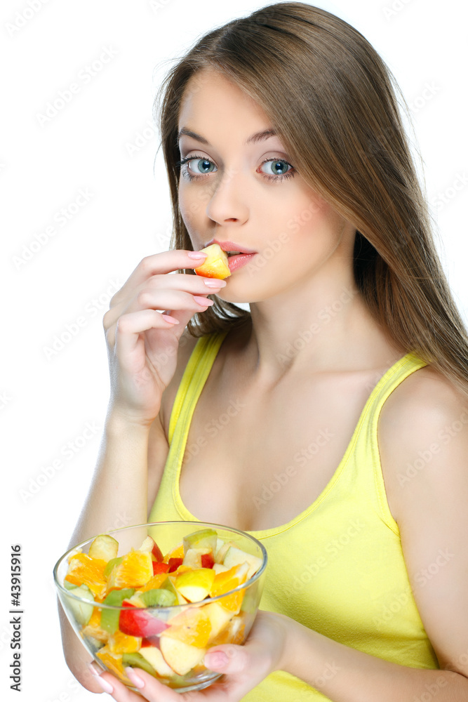Portrait of a young woman eating fruit salad isolated on a white Portrait of a young woman eating fruit salad isolated on a white