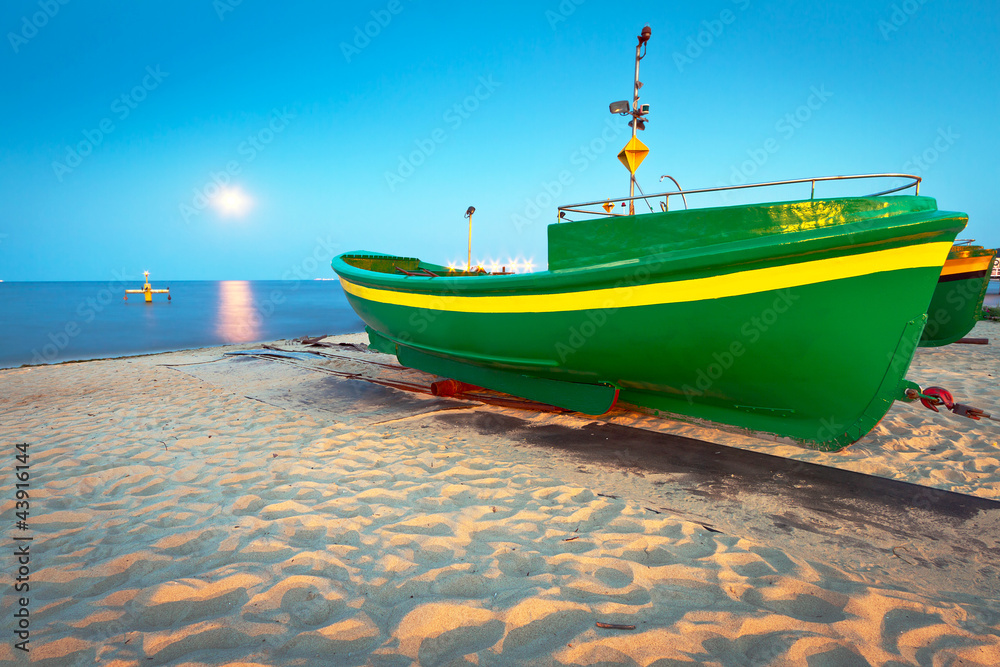 Fototapeta premium Green fishing boat on the beach of Baltic sea, Poland