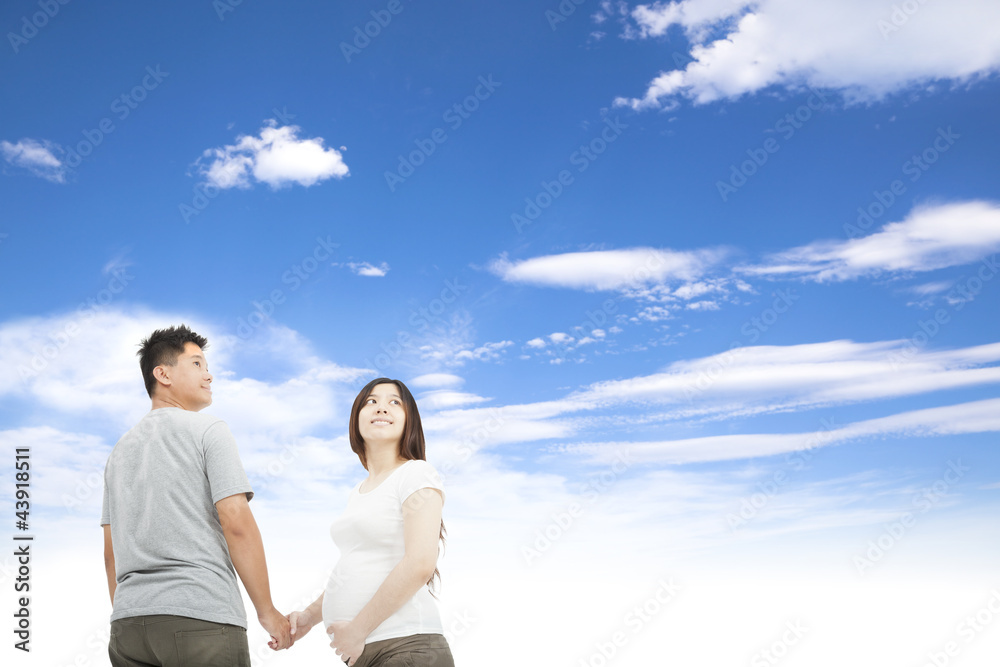 husband holding pregnant wife's hand and cloud background husband holding pregnant wife's hand and cloud background