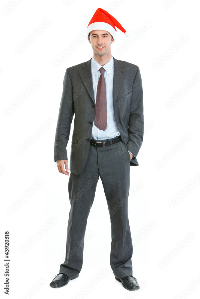 Full length portrait of smiling businessman in Santa's hat Full length portrait of smiling businessman in Santa's hat