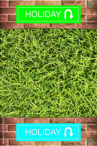 Holiday sign on Grunge brick wall green grass background