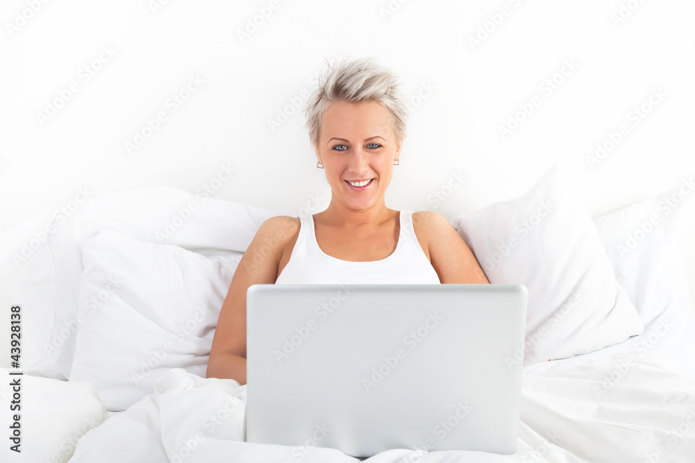 Beautiful blonde woman using a laptop and smiling Beautiful blonde woman using a laptop and smiling