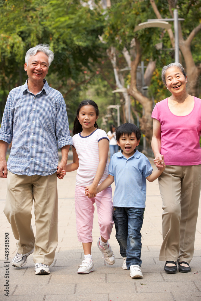 Chinese Grandparents Walking Through Park With Grandchildren Chinese Grandparents Walking Through Park With Grandchildren