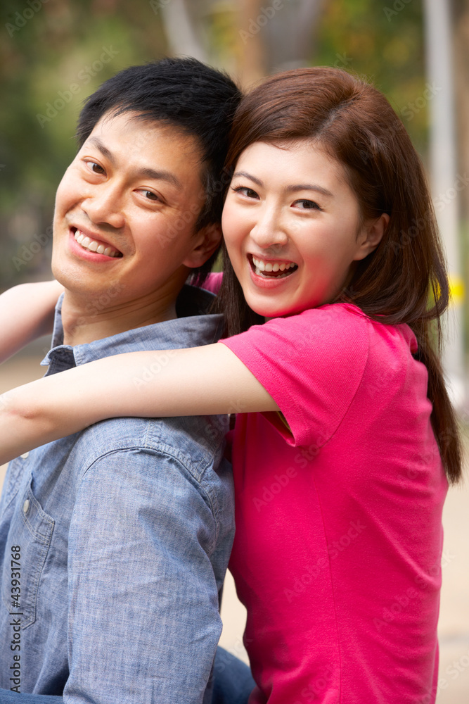 Young Chinese Couple Relaxing In Park Together Young Chinese Couple Relaxing In Park Together