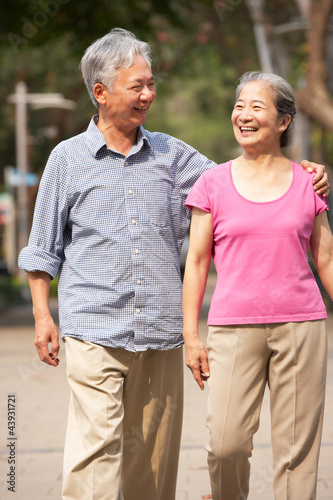 Senior Chinese Couple Walking In Park