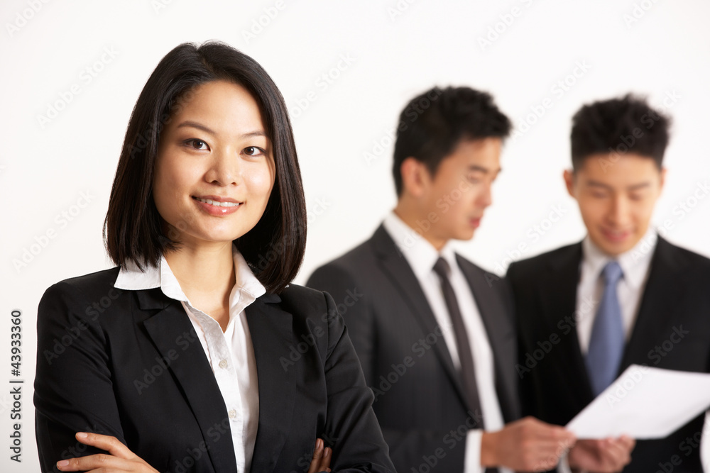 Studio Shot Of Chinese Businesspeople Discussing Document Studio Shot Of Chinese Businesspeople Discussing Document