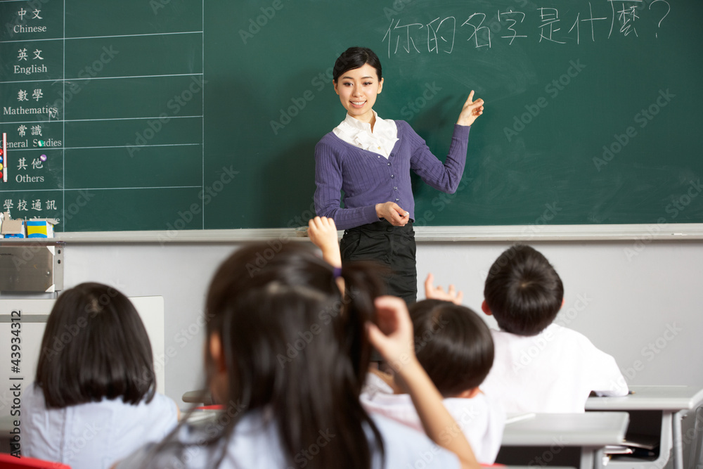 Teacher Standing By Blackboard In Chinese School Classroom Teacher Standing By Blackboard In Chinese School Classroom