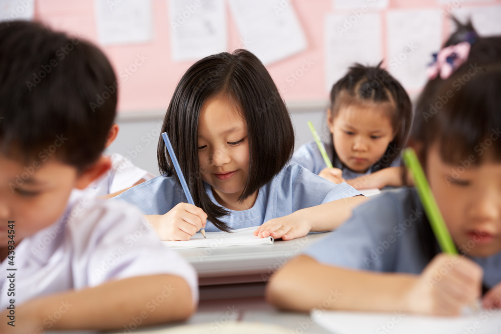 Group Of Students Working At Desks In Chinese School Classroom Group Of Students Working At Desks In Chinese School Classroom