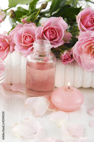 Spa setting with branch roses on towel and candle