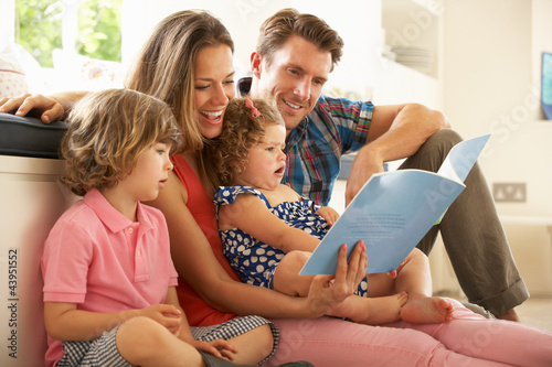 Parents Sitting With Children Reading Story Indoors photo