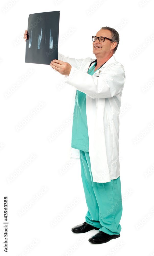 Full length portrait of senior surgeon holding x-ray Full length portrait of senior surgeon holding x-ray