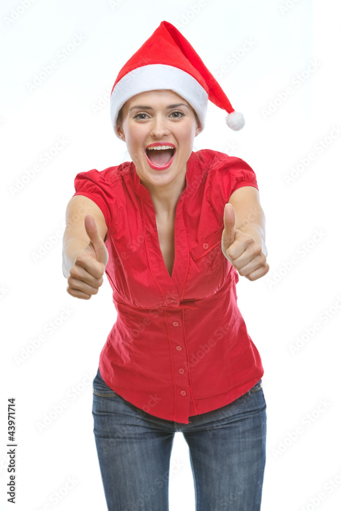 Smiling young woman in Christmas hat showing thumbs up Smiling young woman in Christmas hat showing thumbs up