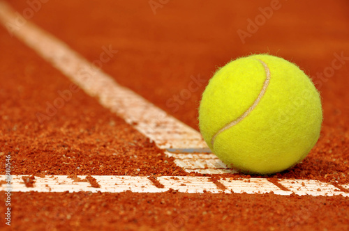 Tennis ball on a tennis clay court © vencav