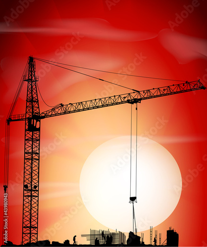 Silhouette of crane on a sunset on building