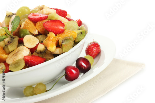 bowl with fresh fruits salad and berries isolated on white