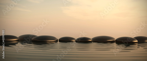 Zen stones in water on sunrise