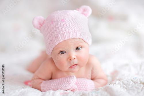 newborn baby girl in pink knitted bear hat