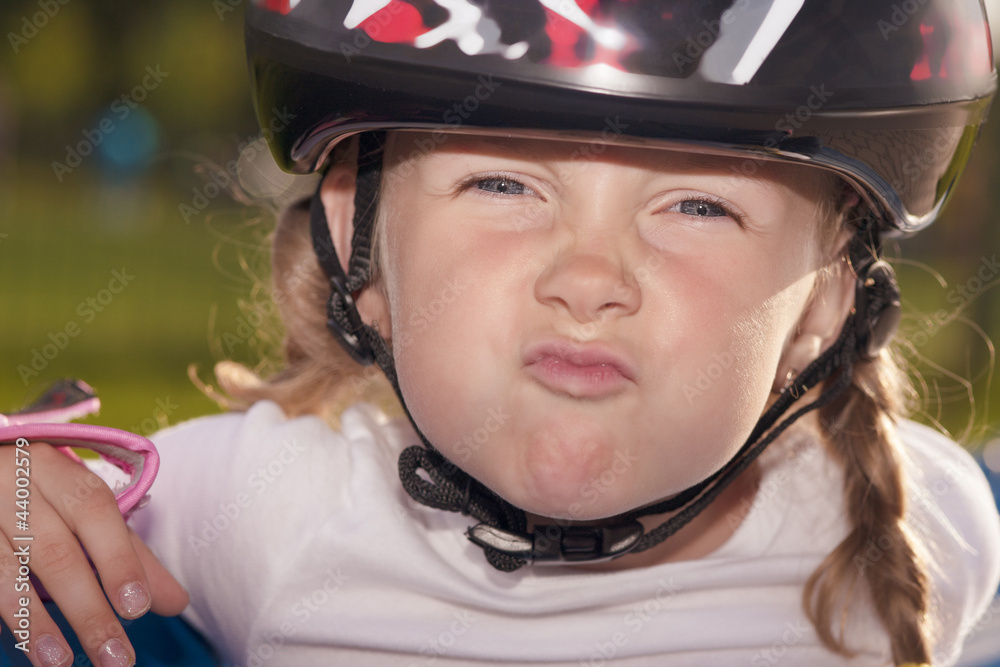 girl in protective helmet making grimace outside girl in protective helmet making grimace outside