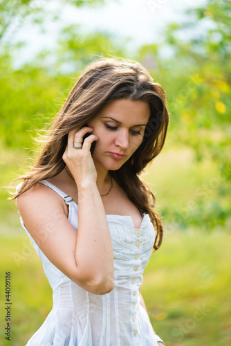 Outdoor portrait of young woman with phone © Valeri Luzina