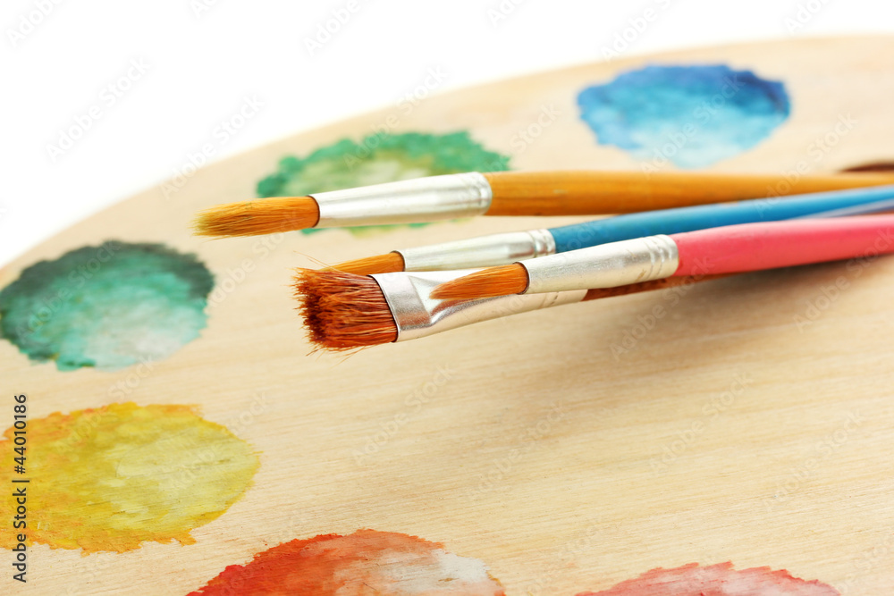 Fototapeta premium wooden art palette with paint and brushes isolated on white