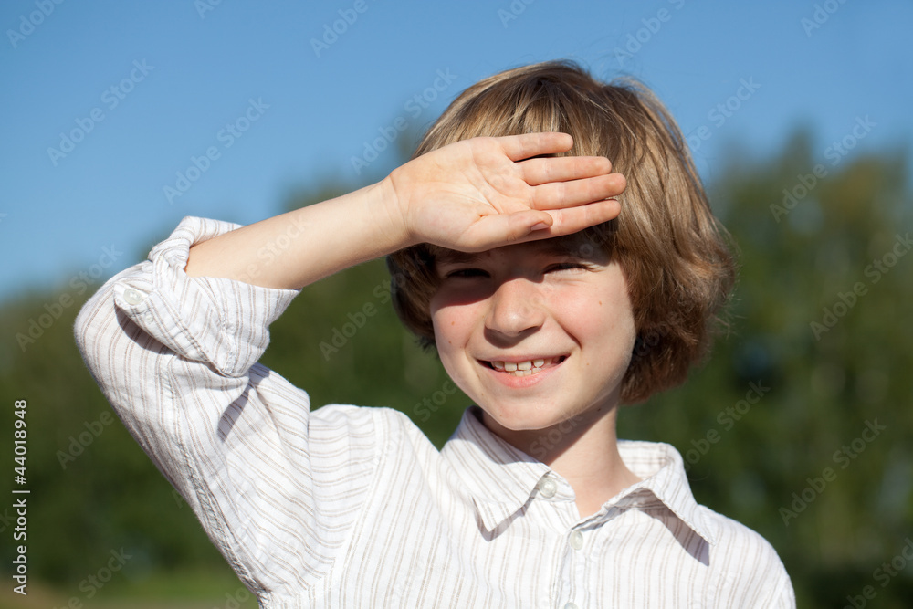 Little boy closes his hand from the sun