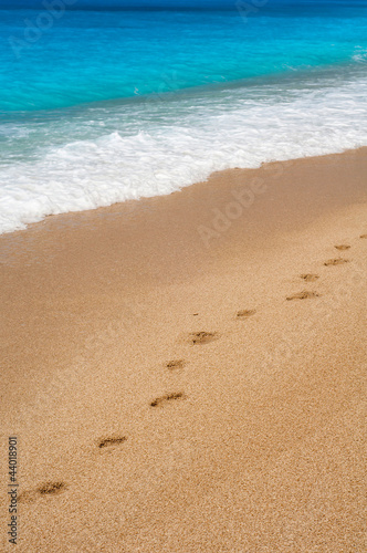 Footsteps on the beach by the wave