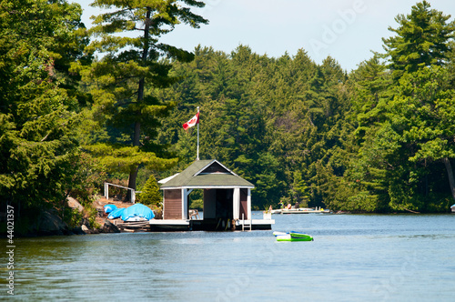 Valokuvatapetti Small boathouse with a Canadian Flag