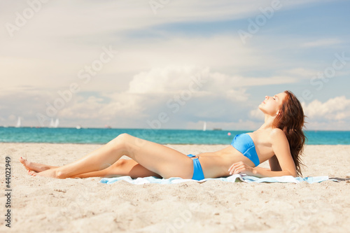 happy smiling woman laying on a towel © Syda Productions