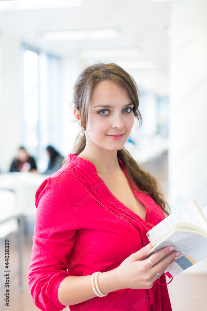 Pretty young college student in a library (shallow DOF; color to