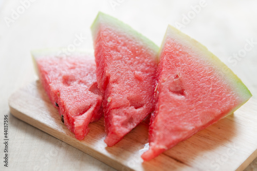 Three slices of watermelon on wooden board
