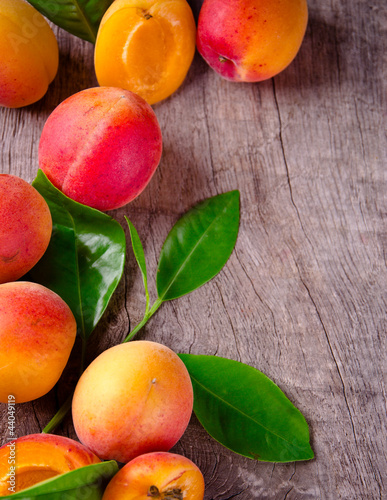 Freshly harvested apricots on wooden background