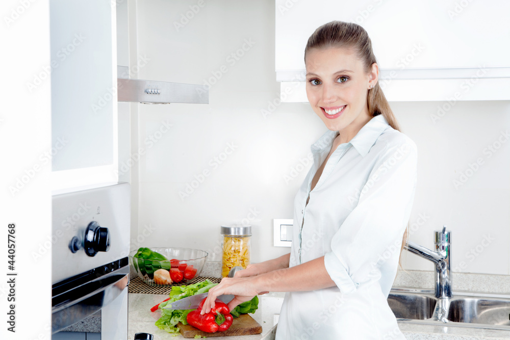 Pretty Female Cutting Vegetables in Kitchen