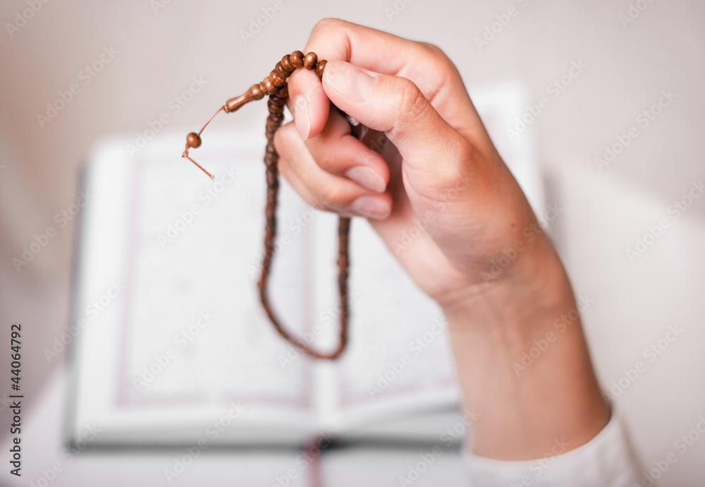 Obraz premium young muslim girl with rosary praying in mosque