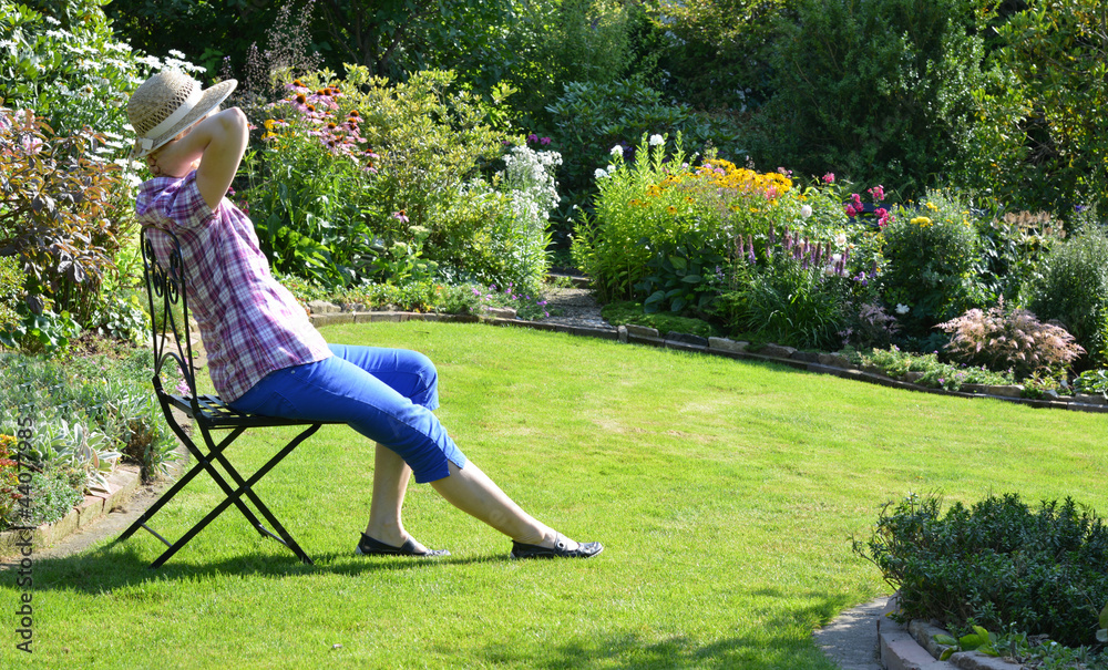 Frau genießt die Sonne im Garten StockFoto Adobe Stock