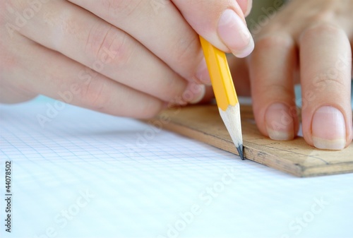 Women s hands are working with a pencil and ruler