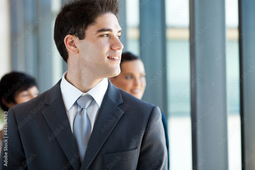 young businessman looking outside office window young businessman looking outside office window