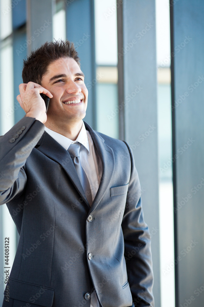 happy young businessman talking on mobile phone happy young businessman talking on mobile phone