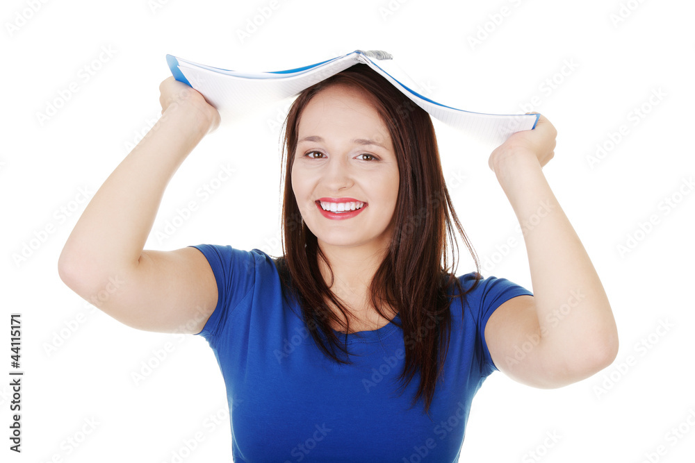 Happy student girl is holding note book above the head. Happy student girl is holding note book above the head.