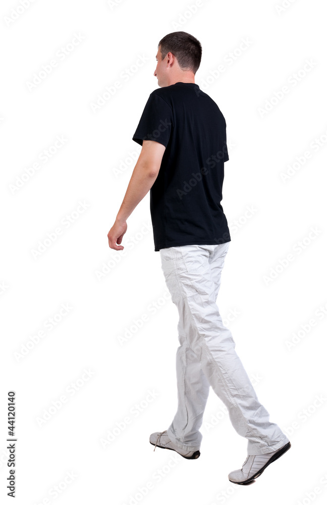 Back view of walking handsome man in t-shirt