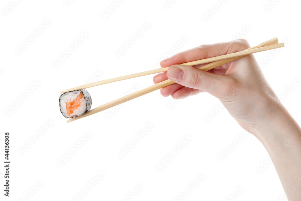 Hand holds the sushi with chopsticks, isolated on white Hand holds the sushi with chopsticks, isolated on white