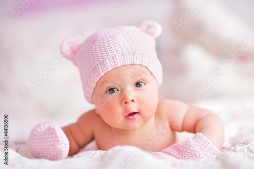 newborn baby girl in pink bear hat and mittens