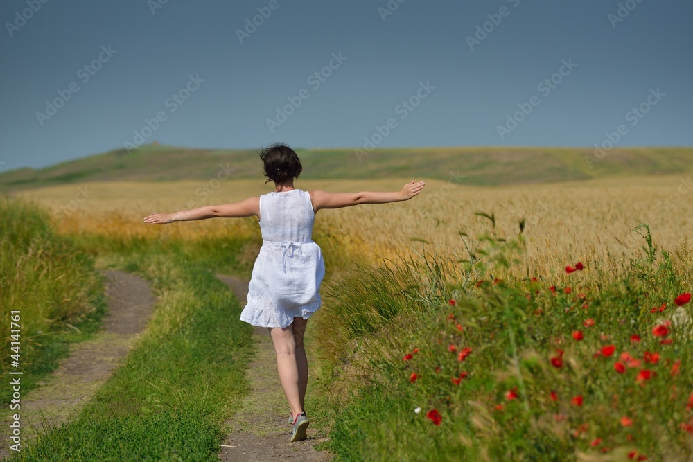 young woman in wheat field at summer