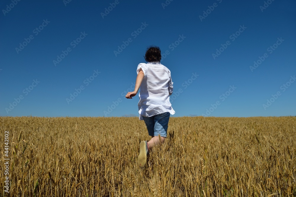 young woman in wheat field at summer