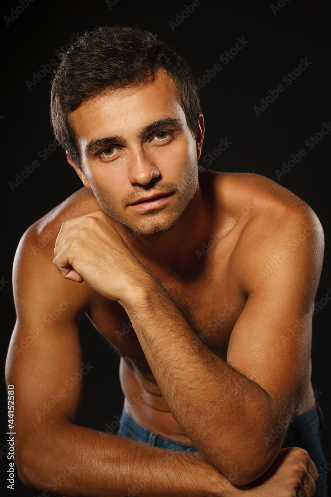 Young muscular male shirtless leaning on the chair Young muscular male shirtless leaning on the chair