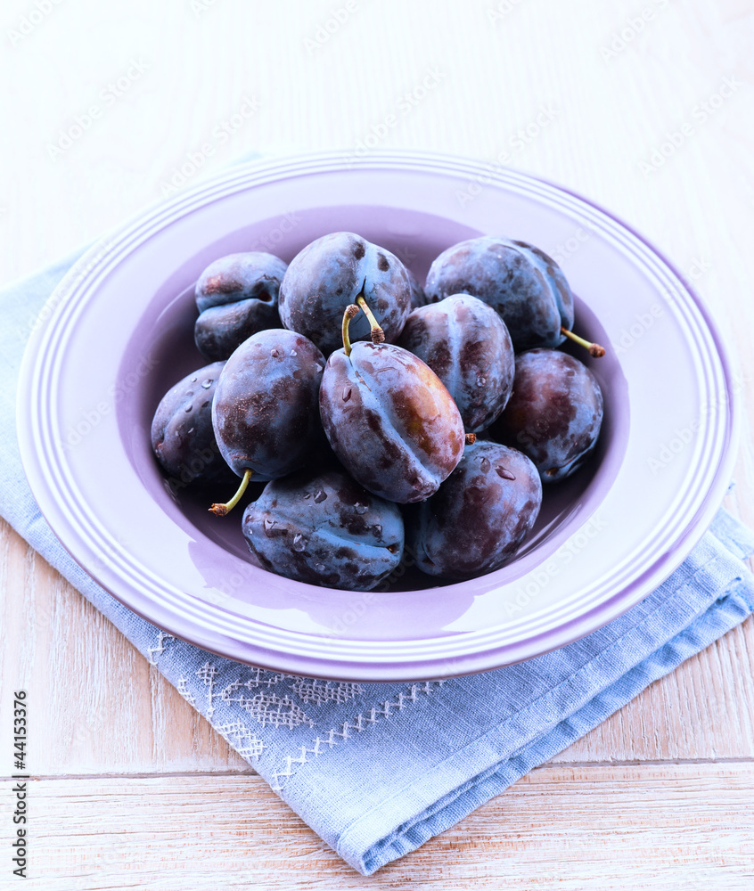 Fresh plums in a purple bowl Fresh plums in a purple bowl