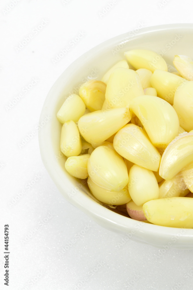 Fresh peeled garlic in a bowl, isolated on white background. Fresh peeled garlic in a bowl, isolated on white background.