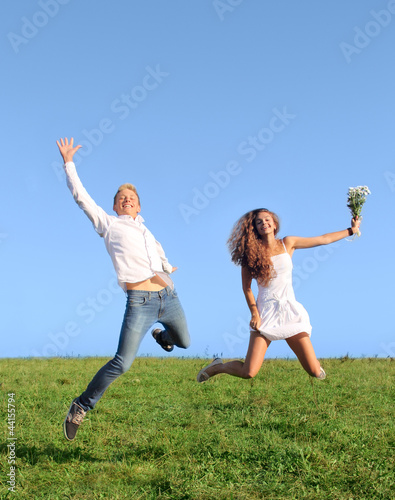 Young couple jumping on field